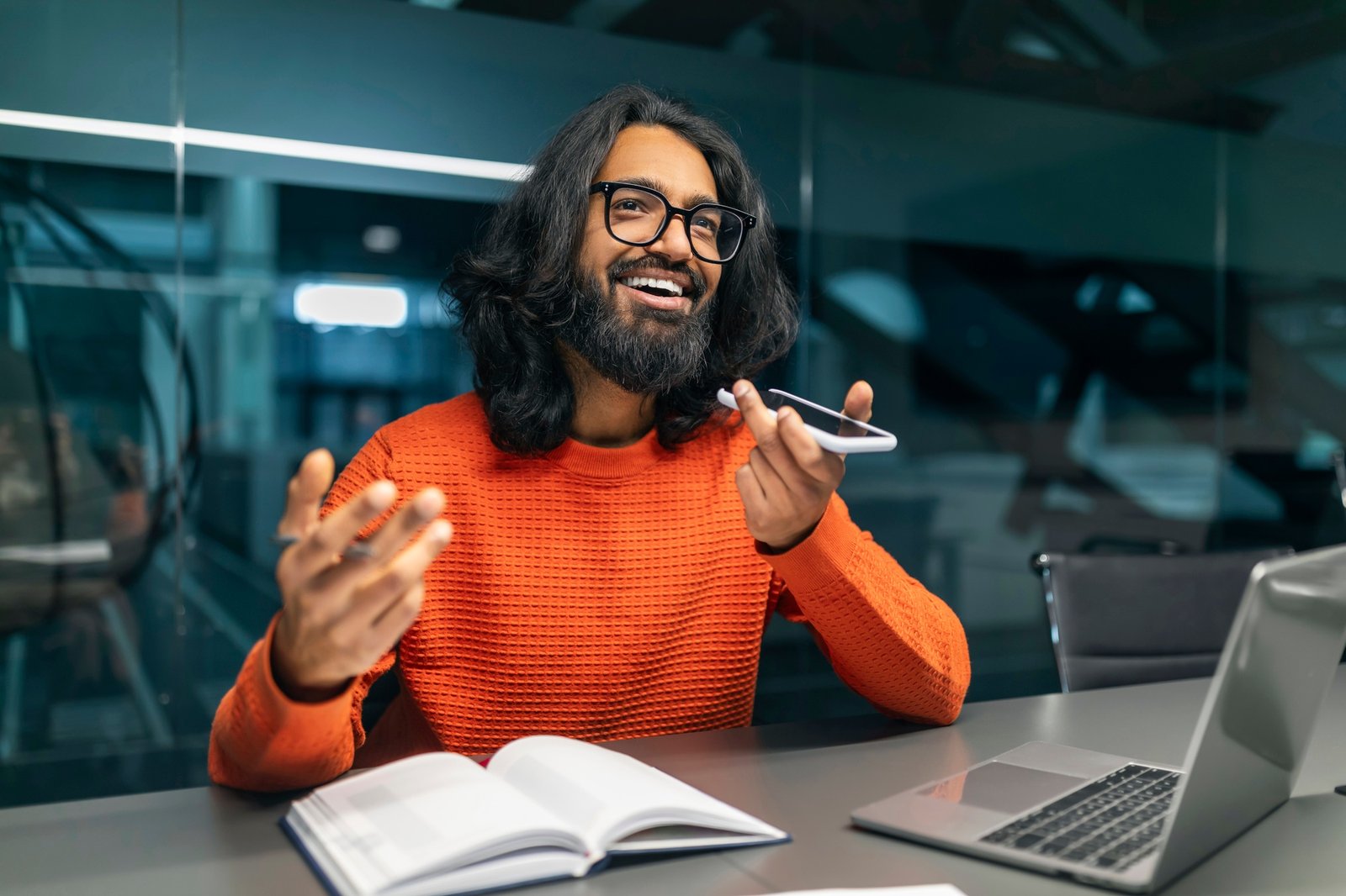Positive millennial indian guy tech professional recording voice message